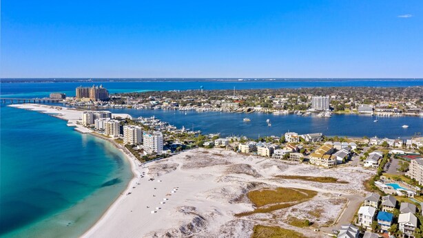 An aerial view of a coastal city with a beach, marina, and residential buildings. - Beach Side Destin Retreat (Destin)