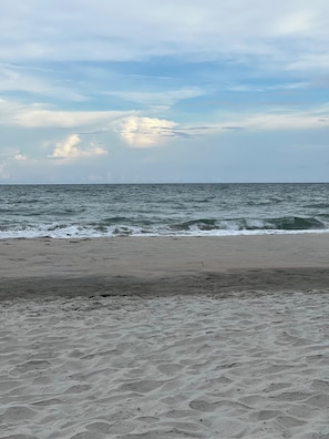 A beach with a sandy shore and the ocean in the background.