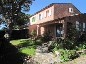 A two-story house with a stone pathway leading to the entrance.