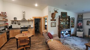 A compact living space with a kitchen, dining area, and a cozy seating area. - Cozy new built home for 2, country living with city near by (West Olive)