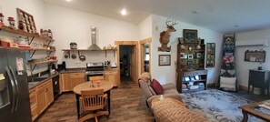 A compact living space with a kitchen, dining area, and a cozy seating area. - Cozy new built home for 2, country living with city near by (West Olive)