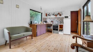 A compact living space with a sofa, kitchenette, and a dining area.