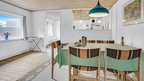Ein Essbereich mit einem runden Tisch, Stühlen und einer hängenden blauen Pendelleuchte.