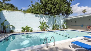 A swimming pool with blue and white tiles, surrounded by lounge chairs and plants. - Downtown Charleston! Walking distance to The Battery! (Charleston)