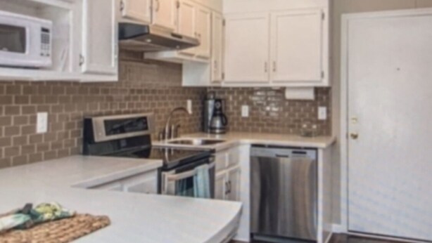 A kitchen with white cabinets, a microwave, a stove, and a dishwasher. - Downtown Charleston! Walking distance to The Battery! (Charleston)