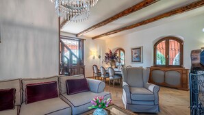 Un salón acogedor con un sofá, un sillón y una mesa de centro con un jarrón de flores.