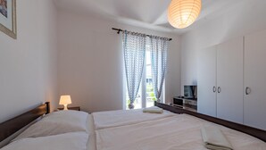 Een hotelkamer met twee bedden, een televisie en een kledingkast.