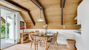 A dining area with a wooden table, chairs, and a hanging light fixture. - Nice home in Løgstrup with WiFi (Løgstrup)