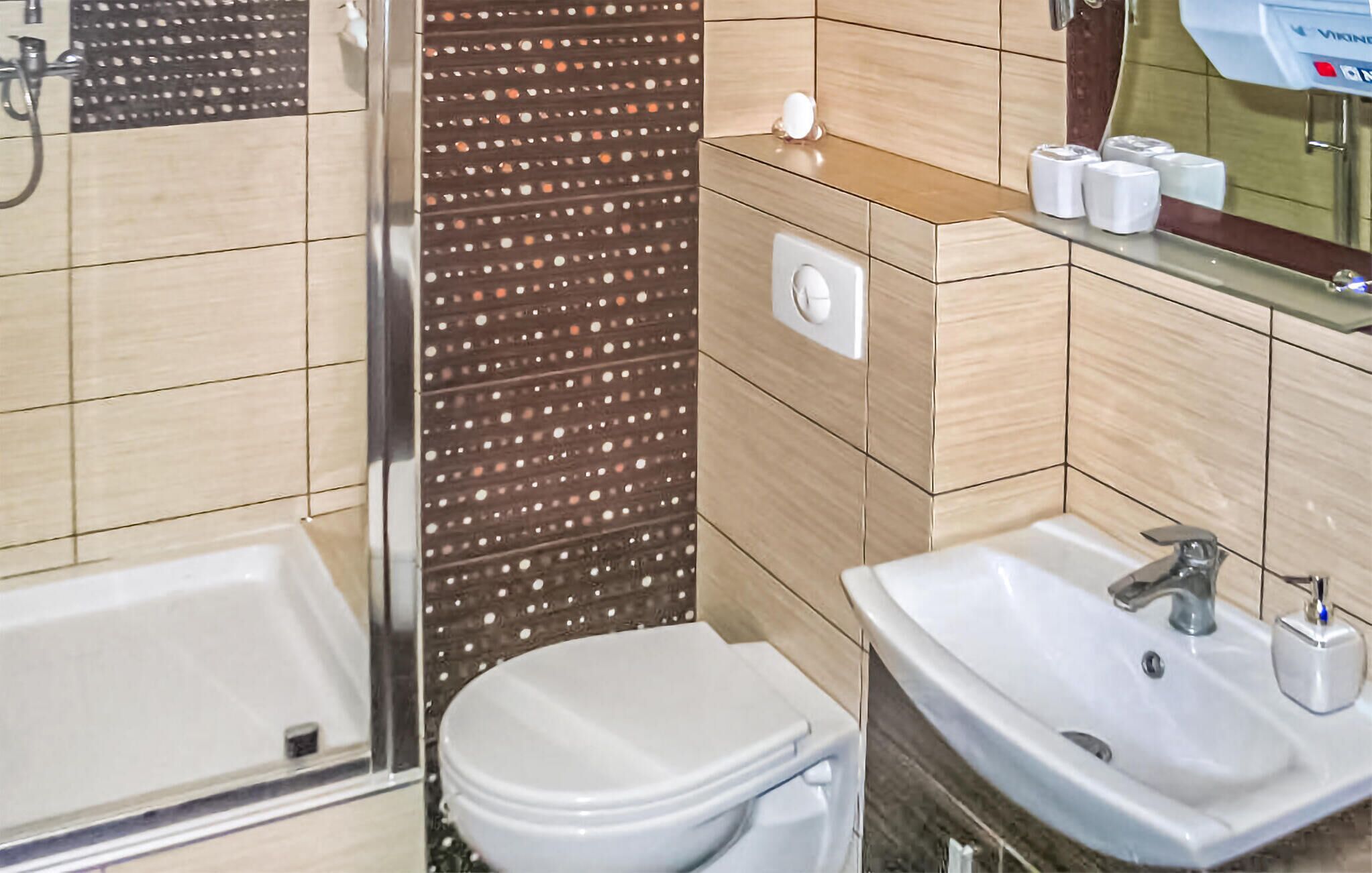 Une salle de bain avec des toilettes, un lavabo et une douche.