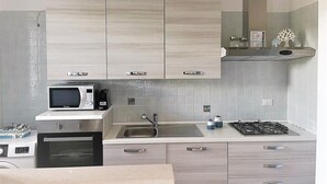 A modern kitchen with a microwave, oven, sink, and stove.