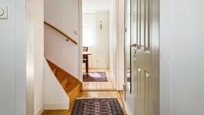 A narrow hallway with a wooden staircase on the left and a door on the right. - Lovely home in Visby with WiFi (Visby)