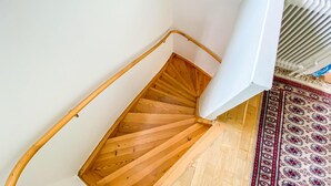A wooden staircase with a white handrail and a radiator on the right. - Lovely home in Visby with WiFi (Visby)