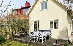 A house with a deck, outdoor seating, and a barbecue grill. - Lovely home in Visby with WiFi (Visby)