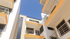 Een meerhoog gebouw met balkons en een bord waarop staat: Washington Court Apartments.