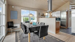 A modern kitchen with a stainless steel refrigerator, a built-in oven, and a large window providing natural light. - Stunning home in Lemvig with WiFi (Lemvig)