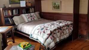 A cozy bedroom with a wooden bed, a bookshelf, and a desk. - Fabulous, restful, studio with AC in charming Hopkinton (Hopkinton)