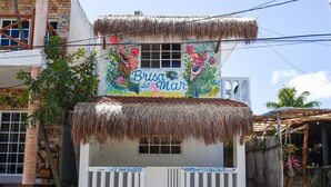 A building with a thatched roof and colorful murals depicting marine life. - Brisa Del Mar (Isla Holbox)