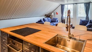 Une cuisine moderne dotée d’un plan de travail en bois, d’un évier en acier inoxydable et d’un four encastré.