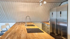 Une cuisine dotée d’un plan de travail en bois, d’appareils électroménagers en acier inoxydable et d’un robinet moderne.