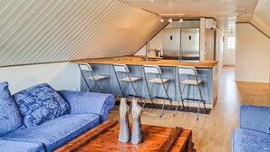 Un espace de vie moderne de style loft, comprenant un coin cuisine, un canapé et une table basse.