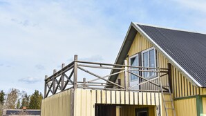 Un bâtiment en construction doté d’une structure en bois et d’une façade jaune.