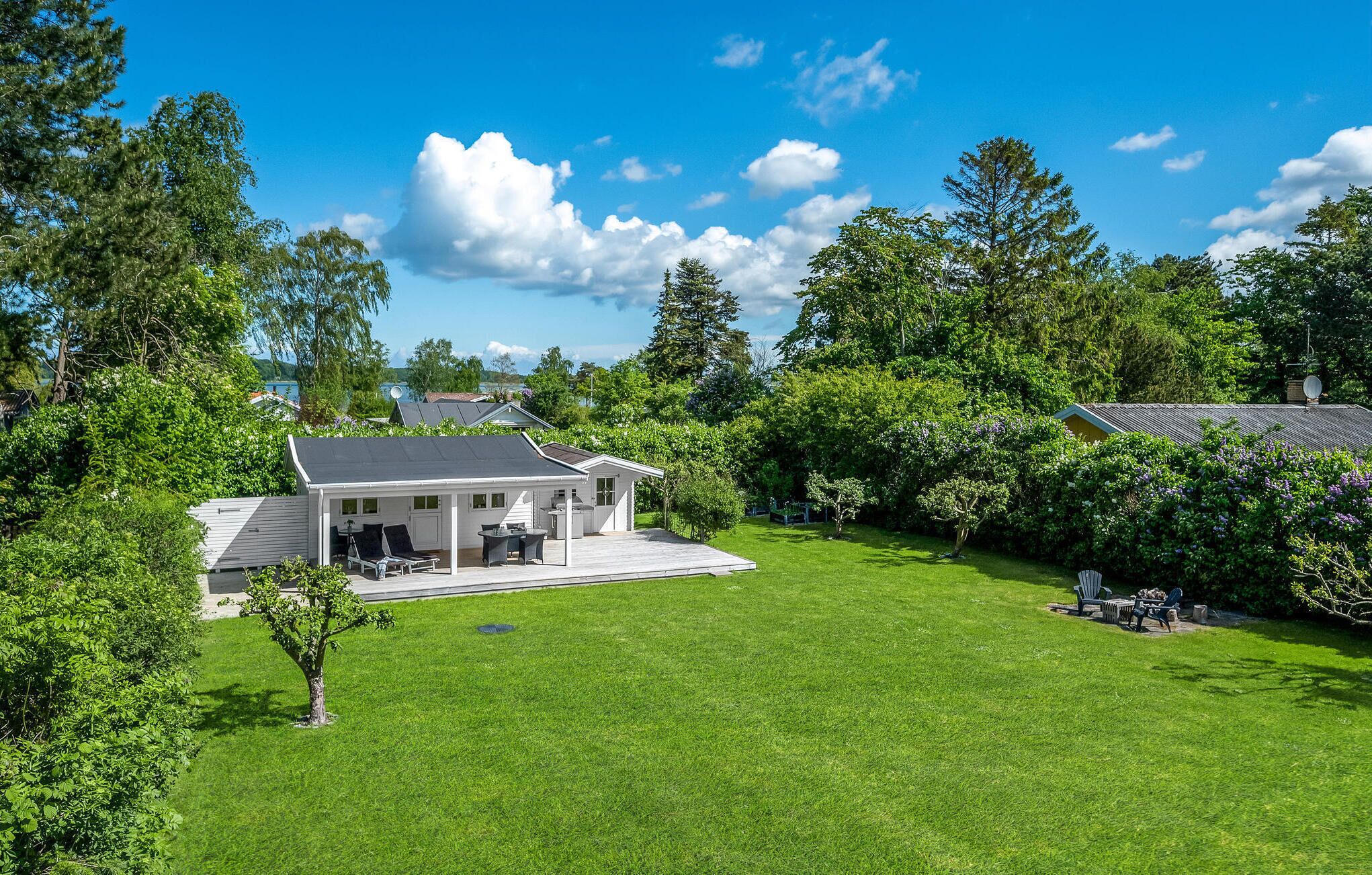 Une maison moderne dotée d’une grande pelouse, d’une terrasse et d’une antenne parabolique.
