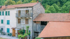 A stone building with a red-tiled roof, a balcony, and a wooden fence. - Amazing home in Loco di Rovegno (Loco di Rovegno)