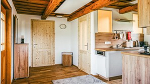 Cocina con vigas de madera, lavavajillas blanco y un armario de madera.