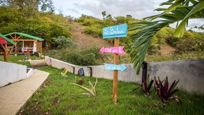 Un panneau indicateur en bois, orné de flèches directionnelles, placé dans un jardin.