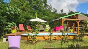 Un espace piscine avec des chaises longues et un coin salon abrité.