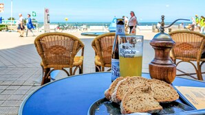 Une table avec une bouteille de bière Blanche de Namur, un verre de bière et des tranches de pain.
