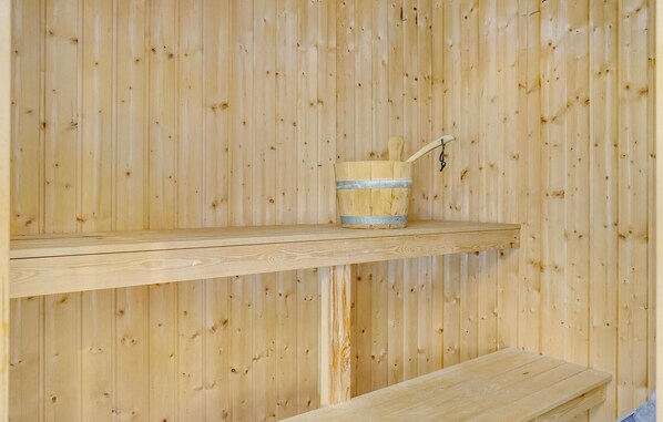 A wooden sauna with a single shelf and a bucket. - Beautiful home in Sjølund with sauna (Sjølund)