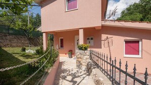 Un edificio a due piani con un vialetto in pietra che conduce all'ingresso.