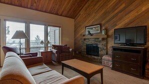 A cozy living room with a fireplace, a television, and a sofa. - Best Location and layout at 7th Mountain 1024 SF 2 Bed/2 Bath - Pet Friendly (Bend)