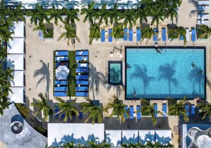 Luftaufnahme eines Resorts mit einem zentral gelegenen Schwimmbad, Liegestühlen und Palmen.