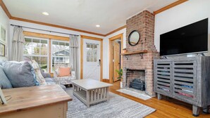 A living room with a fireplace, a television, and a sofa.