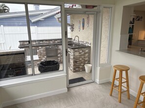 A kitchen with a stone backsplash, a sink, and a window overlooking a backyard. - Beautiful home on a deep water canal leading to the Gulf of America. (New Port Richey)
