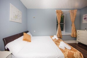 Comfortable retreat with a neatly made bed, dresser, and artwork.