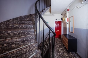 Stairs lead to a landing with a dresser and mirror.