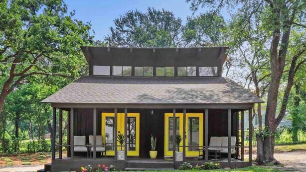 A modern building with a flat roof, large windows, and a covered porch with chairs. - Modern Lakefront Loft Retreat ~ Private Beach & Water Toys (Little Elm)