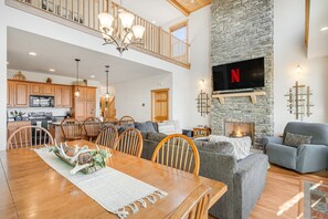Cozy living area with a fireplace, sofa, armchairs, and dining table.