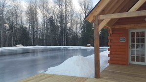 A wooden cabin with a porch and a sign indicating it's open. - Winter ‘27 Seasonal Available-Dog Friendly Chalet in the Woods + Pool, Mt. Snow (Wilmington)