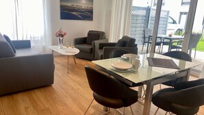 Una sala moderna con una mesa de vidrio, dos sofás y una mesa de centro.