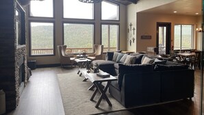 Un salon spacieux doté d’une grande fenêtre, d’une cheminée et d’un coin repas.