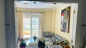 A modern living room with a sofa, a sink, and a potted plant. - Charming beach apartment. Urb Canela Park (Playa de Isla Canela)