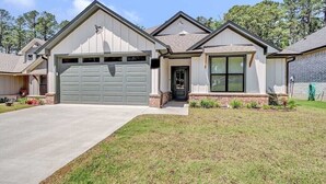 A single-story house with a garage, a front door, and a small front yard.