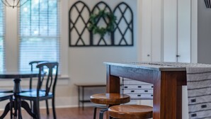 Un coin repas avec une table et des chaises en bois, un lustre et un élément décoratif mural.