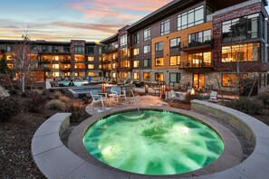 A modern hotel with a heated outdoor pool, lounge chairs, and a well-lit courtyard. - Ski-in/out Dream Location with unparalleled access, views, amenities. Pool, Hot Tubs, Fitness Center (Park City)