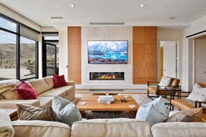 Una sala de estar moderna con un televisor grande, chimenea y asientos cómodos.