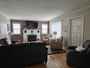 Cozy living room with a fireplace, television, and comfortable seating area.